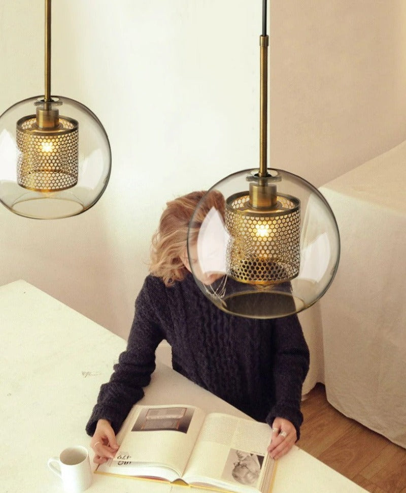 overhead view of clear glass pendant lights with interior honeycomb shade shown in brushed gold finish