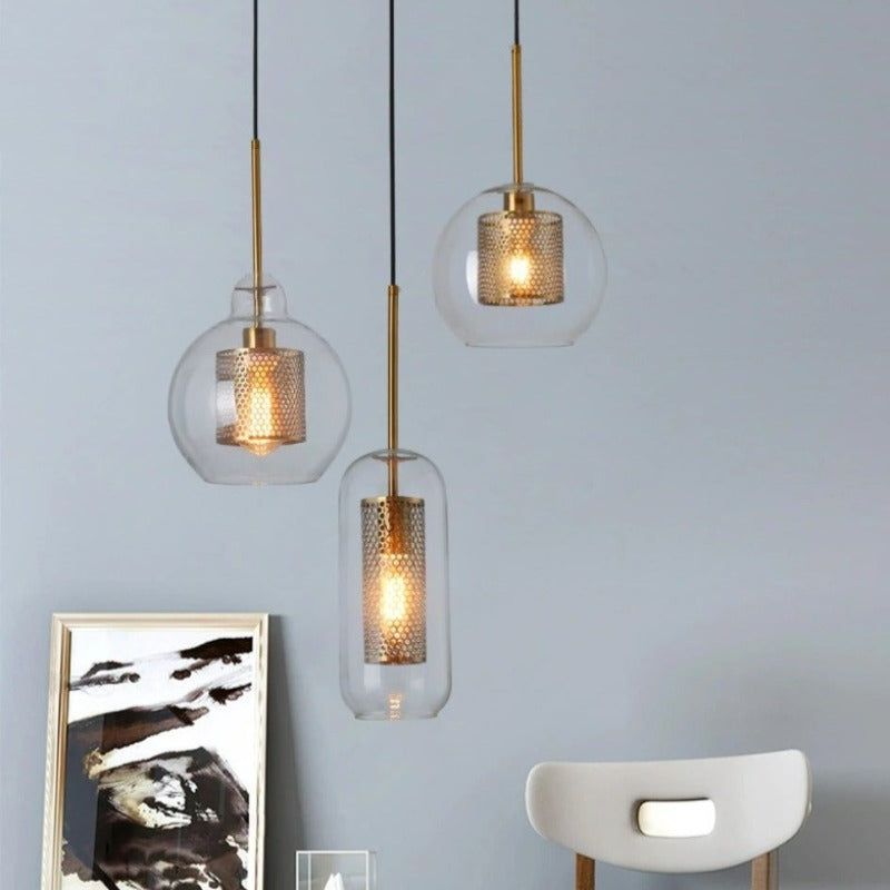clear glass pendant lights in various shapes with interior honeycomb shade shown in brushed gold finish