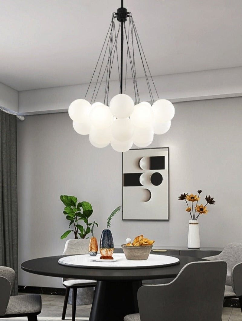 modern multi-globe bubble chandelier with black hardware in small shown over a dining room table