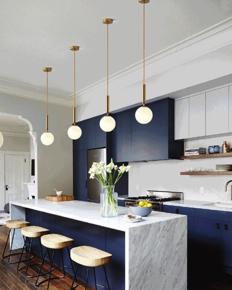 Modern pendant lights shown illuminating a kitchen island