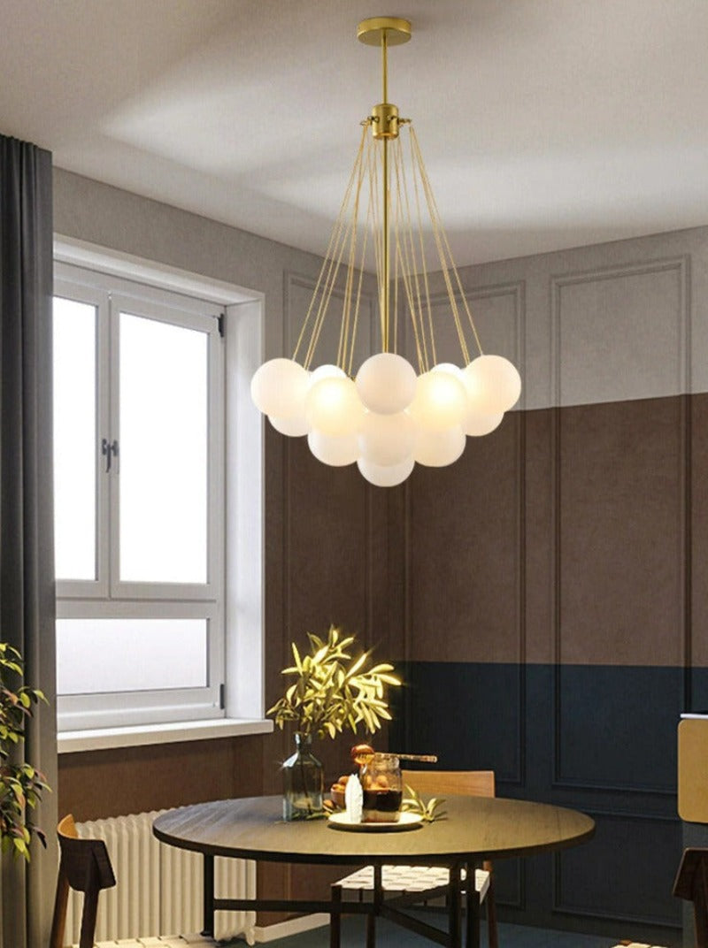 contemporary modern multi-globe bubble chandelier that looks like clouds with gold hardware in small shown hanging over a dining table