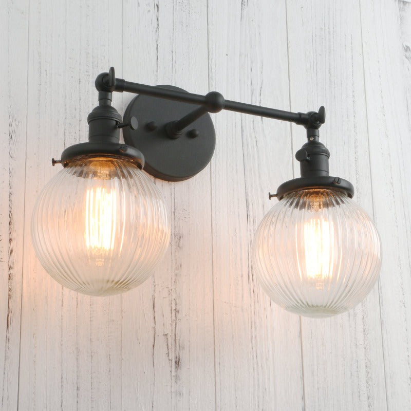 Vintage Double Wall Sconce with clear ribbed glass globes shown in black at an angle with lights on