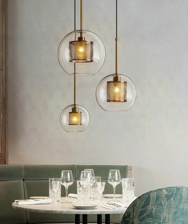 clear glass globe pendant lights with interior honeycomb shade shown in brushed gold finish
