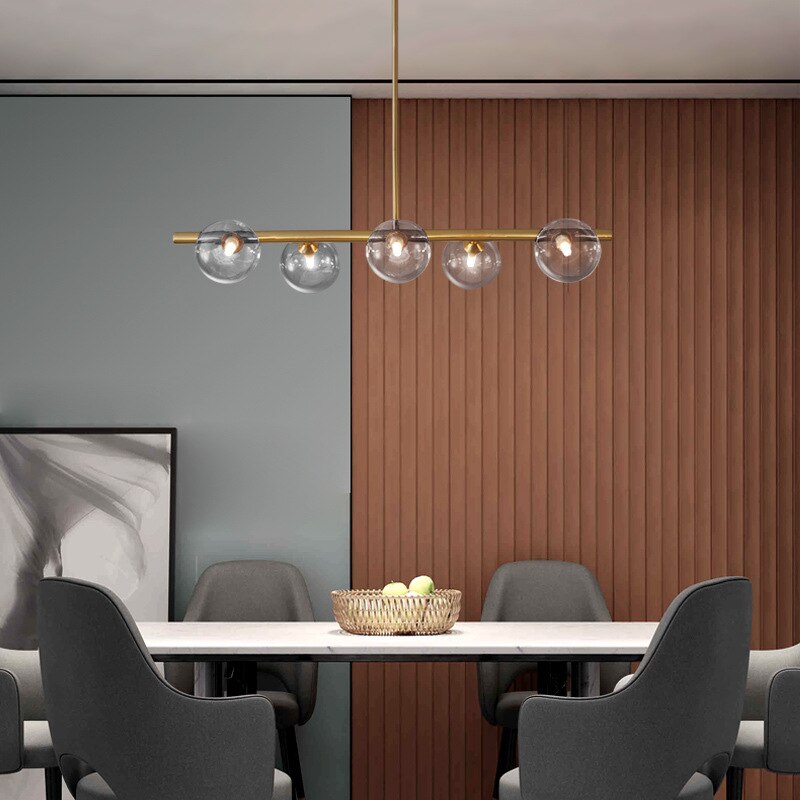 five globe modern horizontal chandelier shown over a dining room table