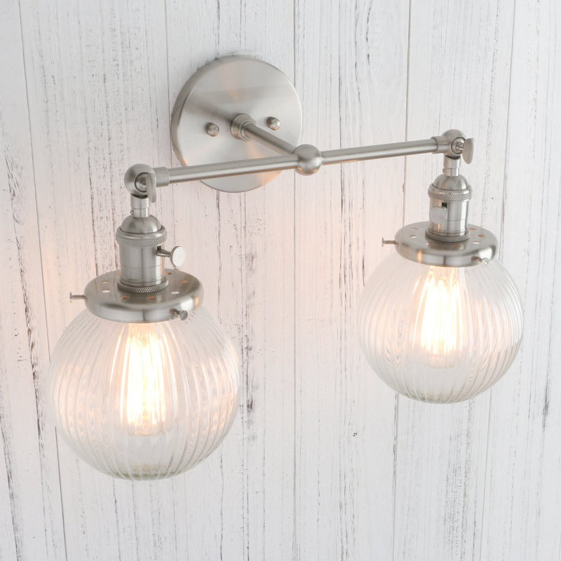 Vintage Double Wall Sconce with clear ribbed glass globes shown in nickel finish shown at an angle with lights on