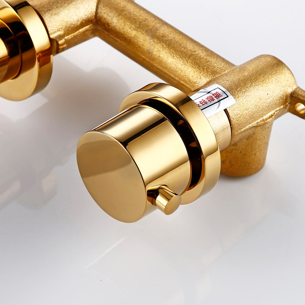 Close up of round handle of contemporary wall mounted bathroom faucet shown in polished gold