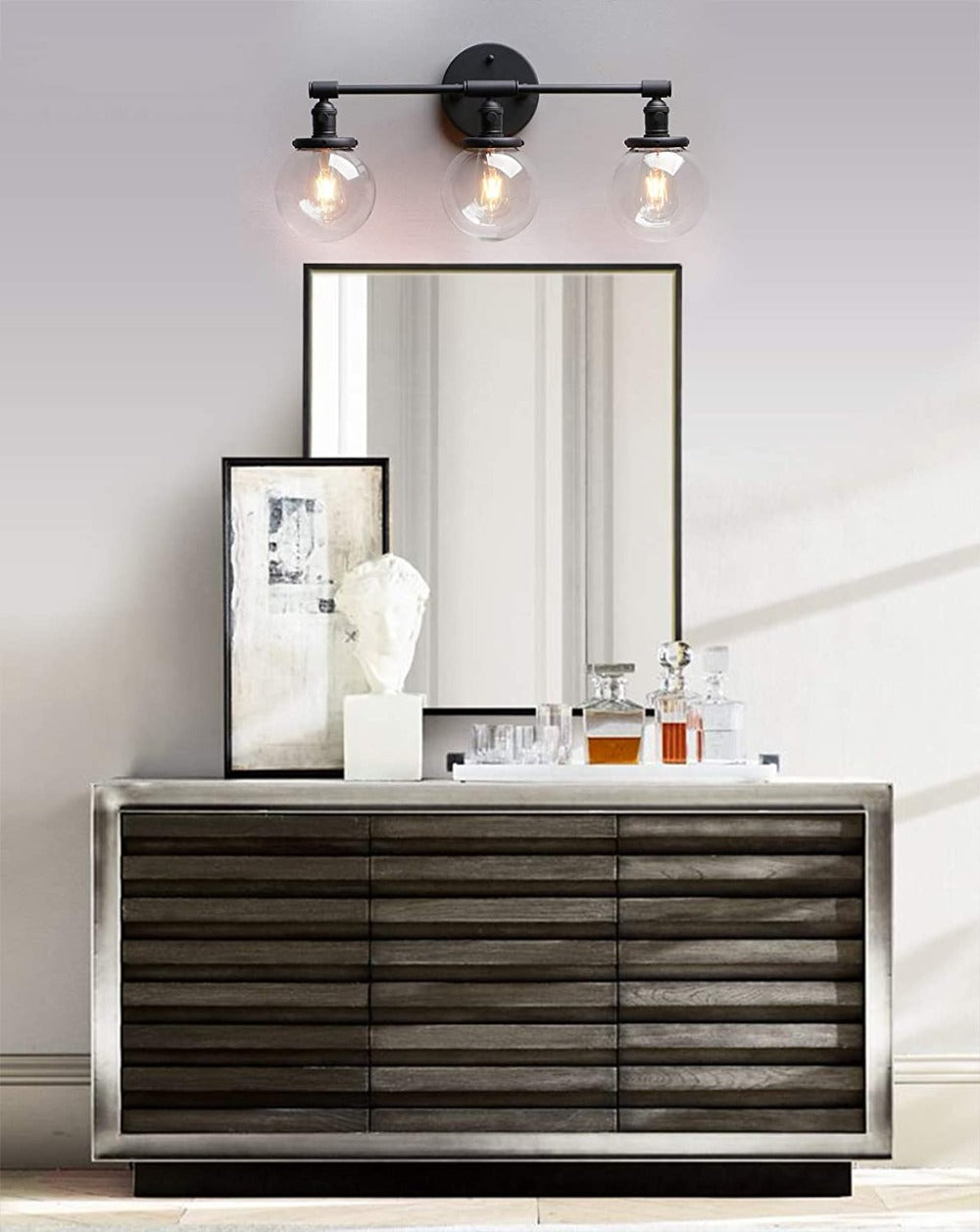 Three Light Bathroom Vanity Lighting with Clear Glass Globes and matte black hardware shown above a bathroom vanity