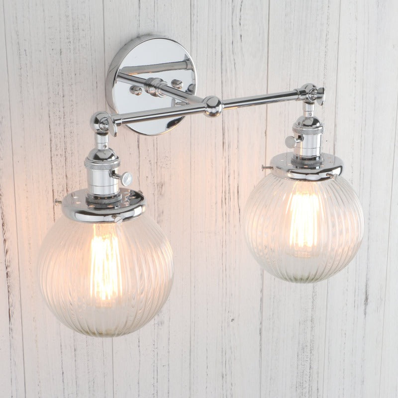 Vintage Double Wall Sconce with clear ribbed glass globes shown in chrome at an angle with lights on
