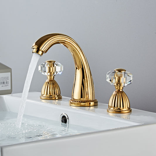 Side view of Gold bathroom faucet  with faceted crystal handles. Fluted Design. Deck mounted, three hole with two handles