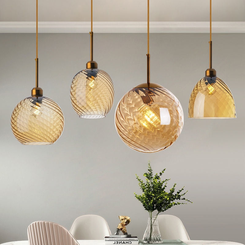 Amber hanging pendant lights shown hung over a dining room table