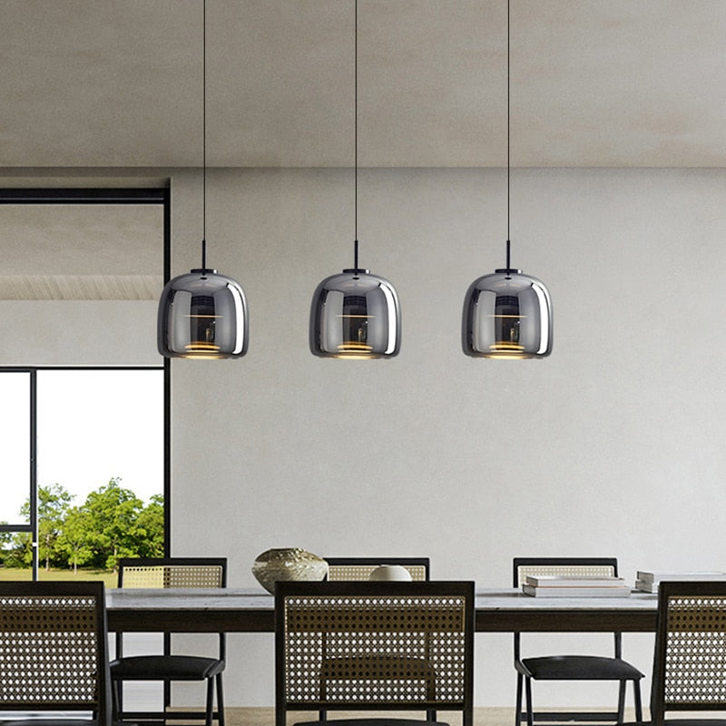 Modern pendant lighting with reflective smoky grey shade shown hung in a group of three