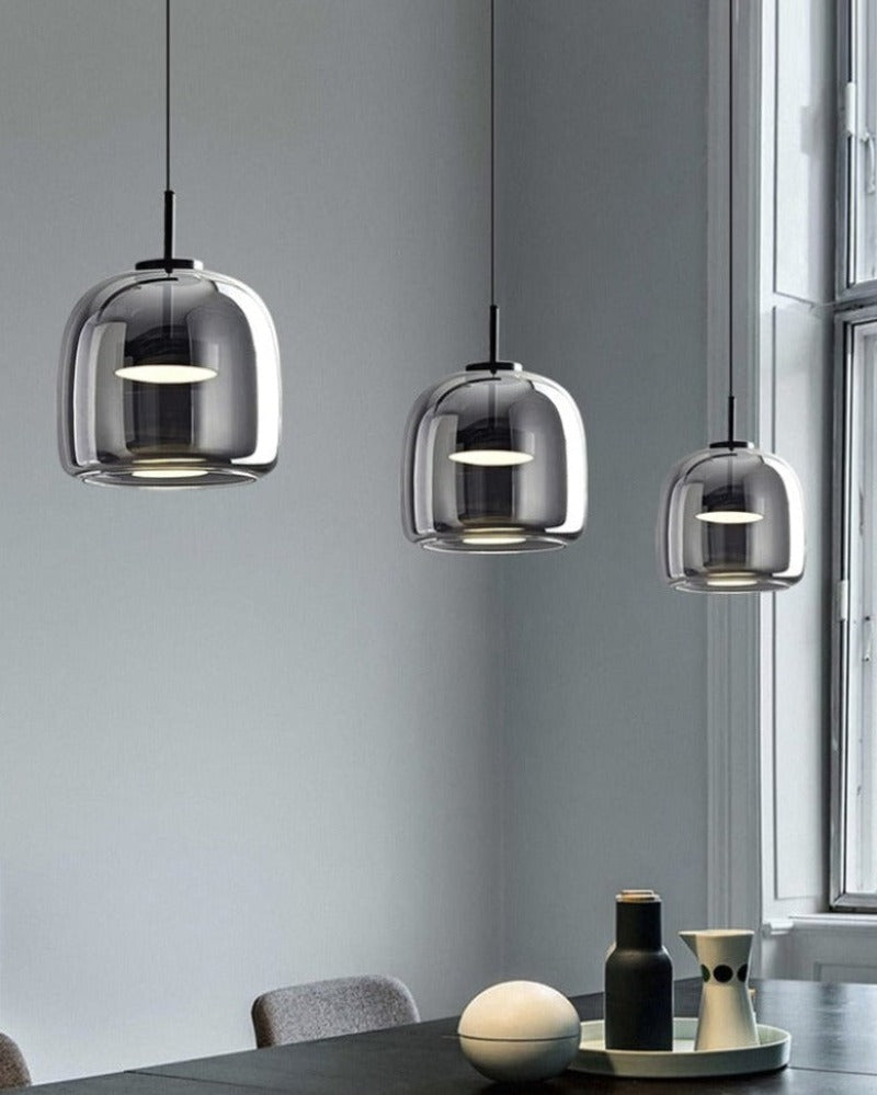 Modern pendant lighting with reflective smoky grey shade shown hung over an office conference table