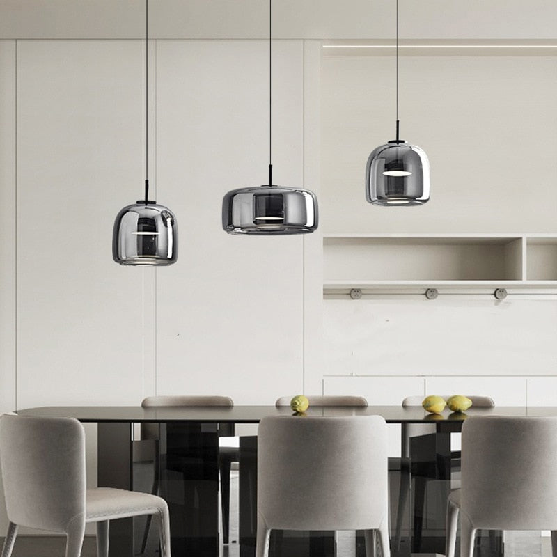Modern pendant lighting with reflective smoky grey shade shown hung in a grouping