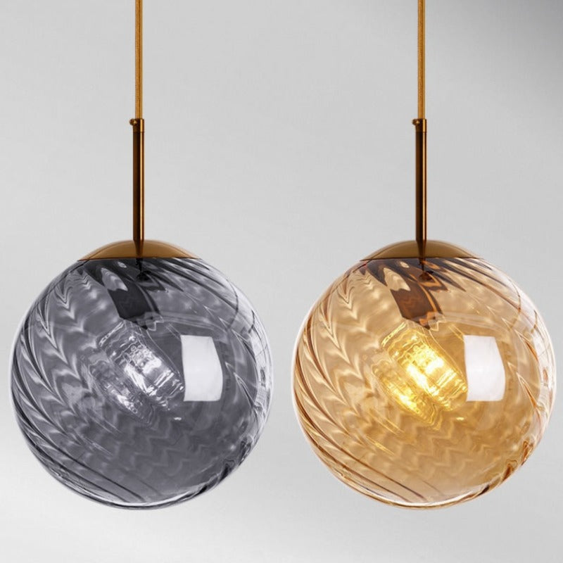 Pendant globe lights shown with gray and amber glass globes