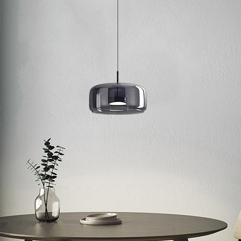 Modern pendant lighting with reflective smoky grey shade shown hung over a kitchen table