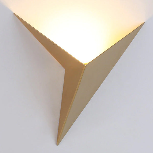 Gold geometric wall sconce shown against a white wall shown on