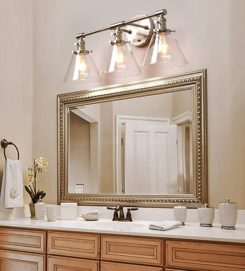 Vintage three light Vanity Wall Sconce in brushed nickel shown above bathroom vanity