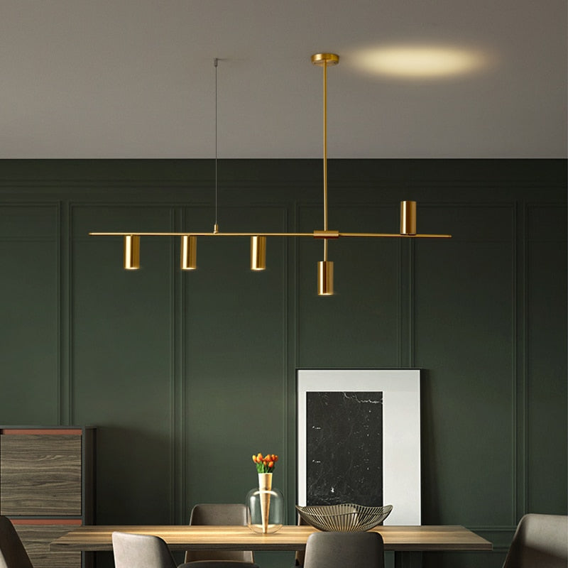 Modern horizontal chandelier in gold shown in dining room