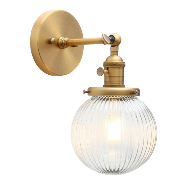 Farmhouse wall sconce with ribbed clear glass globe shown in brushed gold hardware